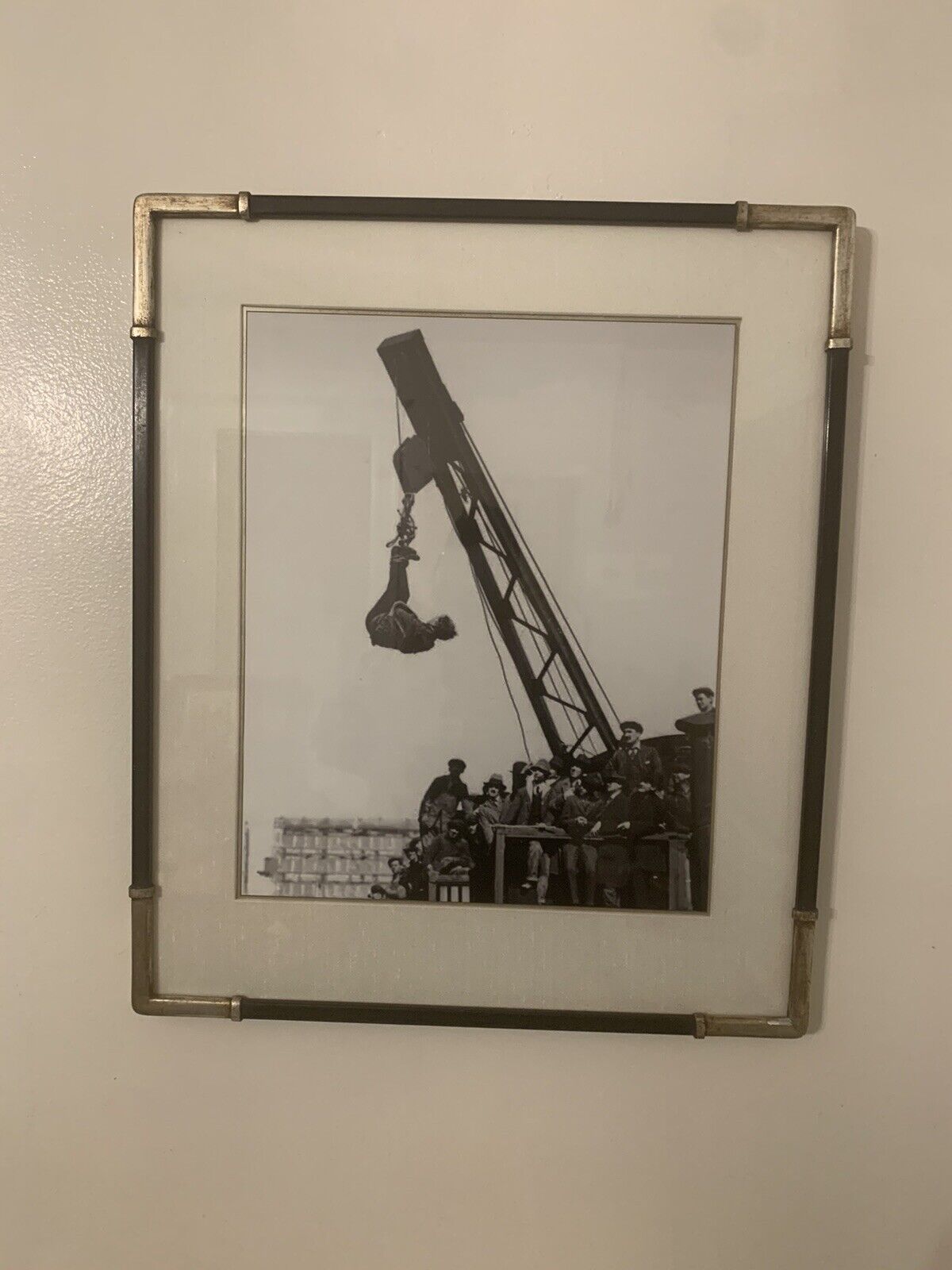 Framed print of Houdini hanging from crane in Straight Jacket 22.5 x 18.5”