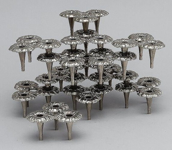 13 design candlesticks in white metal, can be assembled into modules.
