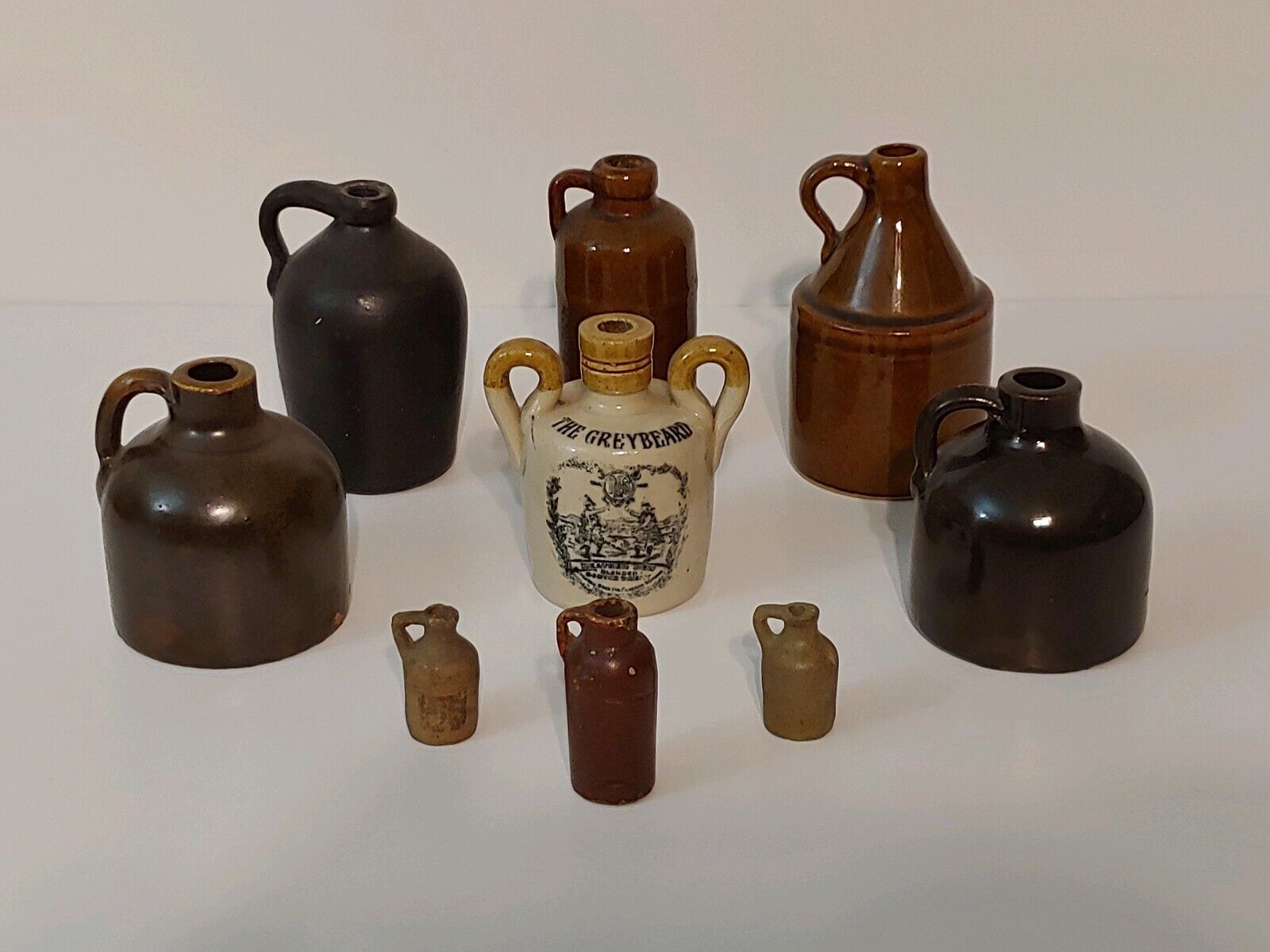 Lot of Nine (9) Antique Small Stoneware Whiskey Rum Moonshine Jugs GREYBEARD