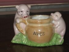 Vintage pigs figurines next to jar marked Ashes picture