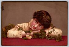Victorian era trading card, girl with her head down on table with rose leaves picture