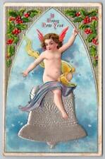 1914 HAPPY NEW YEAR CHERUB ANGEL ON SILVER BELL HOLLY BERRIES EMBOSSED POSTCARD picture