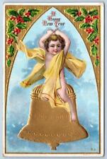 1914 HAPPY NEW YEAR CHERUB ANGEL ON GOLD BELL HOLLY BERRIES EMBOSSED POSTCARD picture