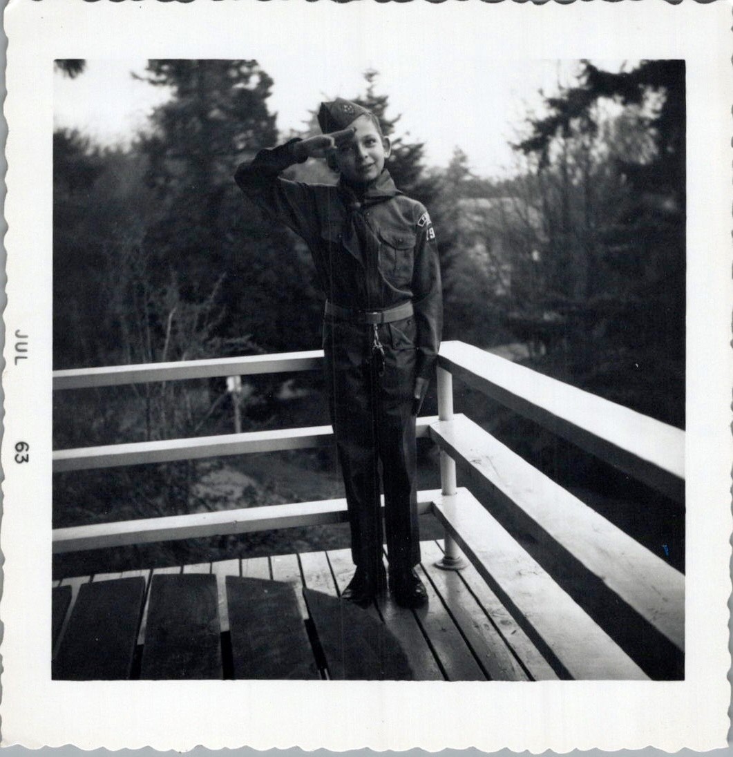 1963 Photograph of Young Boy in Scouting Uniform Saluting on Wooden Deck 1963 Photograph of Young Boy in Scouting Uniform Saluting on Wooden Deck