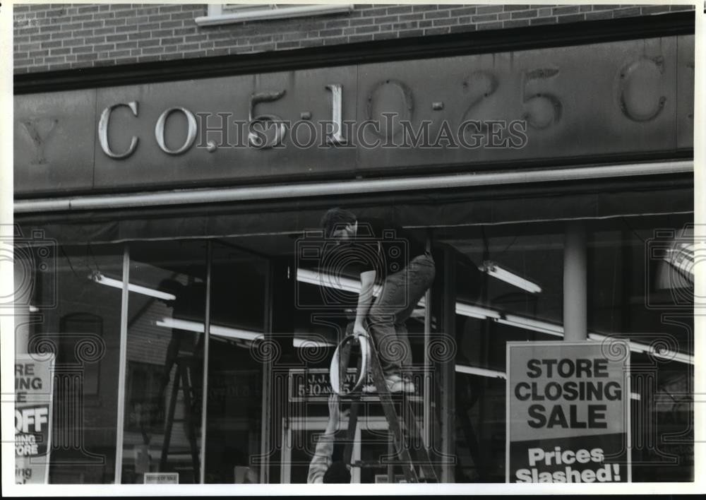 1992 Press Photo Worker removes letters from the J.J. Newberry storefront
