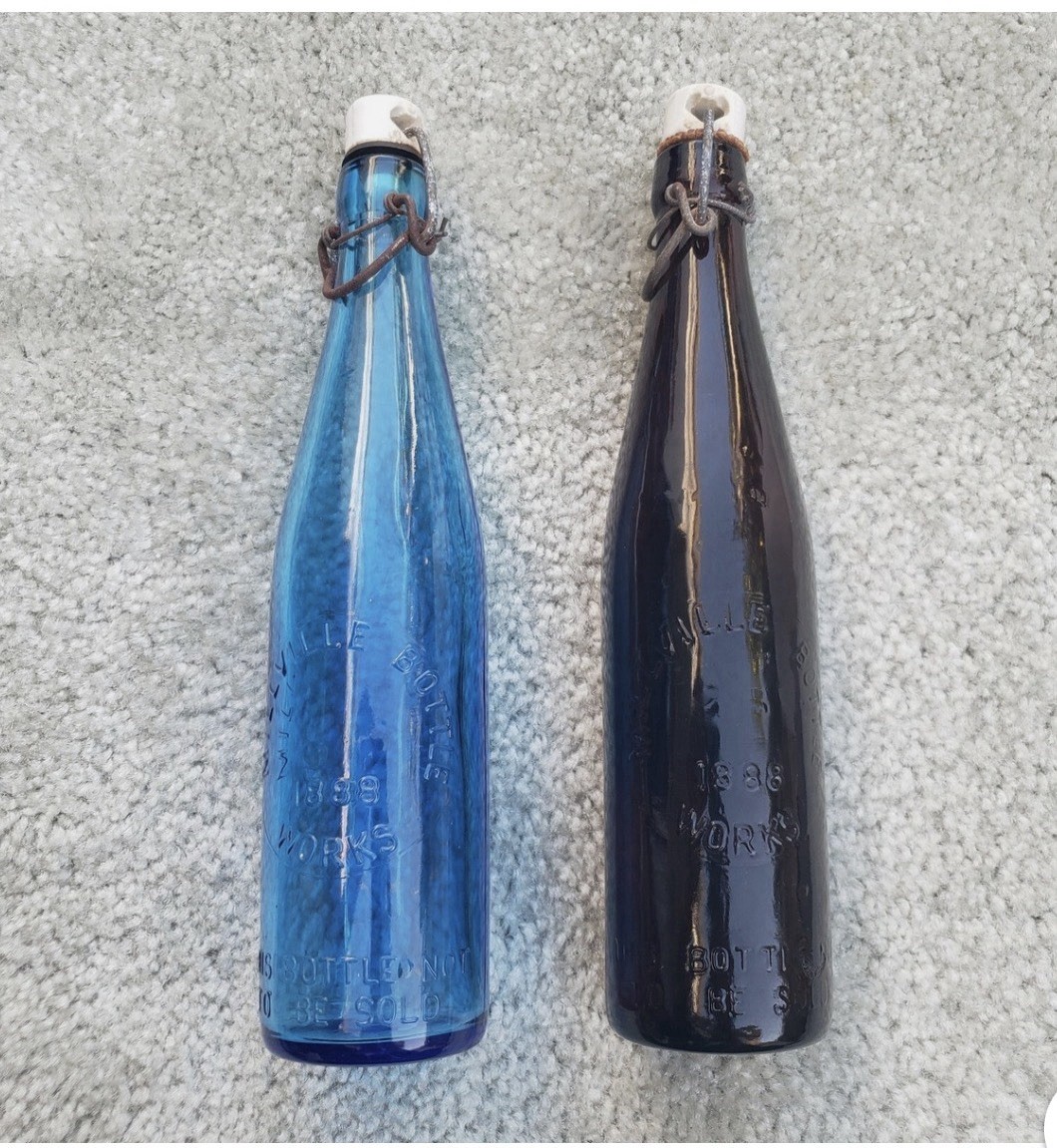 Antique Millville Bottle Works glass bottles. (Amber and blue) Antique Millville Bottle Works glass bottles. (Amber and blue)