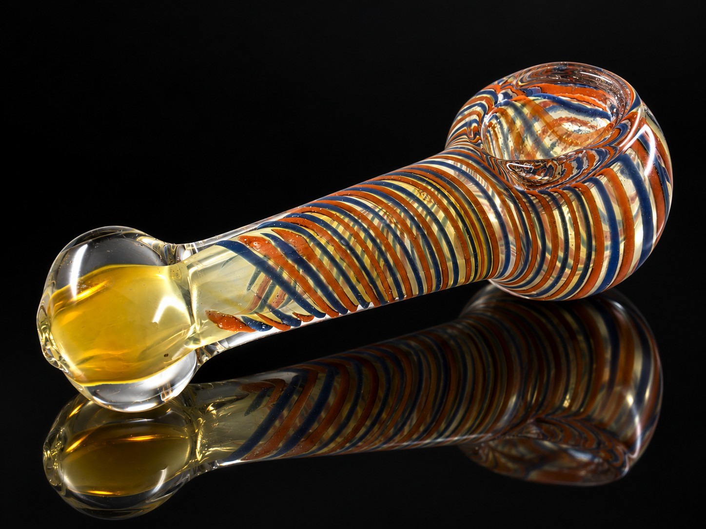 A beautiful art glass tobacco hand pipe featuring warm golden amber and yellow