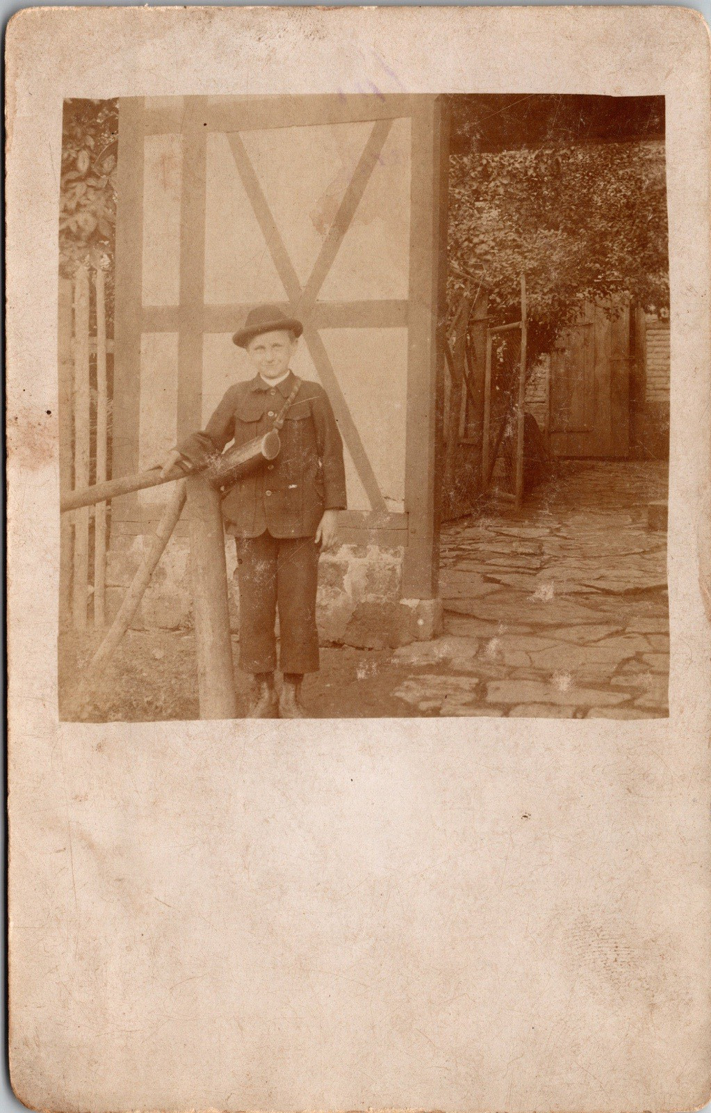 Postcard Real Photo RPPC Boy Wearing Hat Standing Next to Wooden Fence