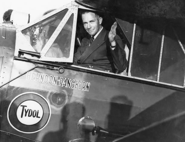 Clyde Pangborn is seated in the cockpit of his plane waving goodbye Old Photo