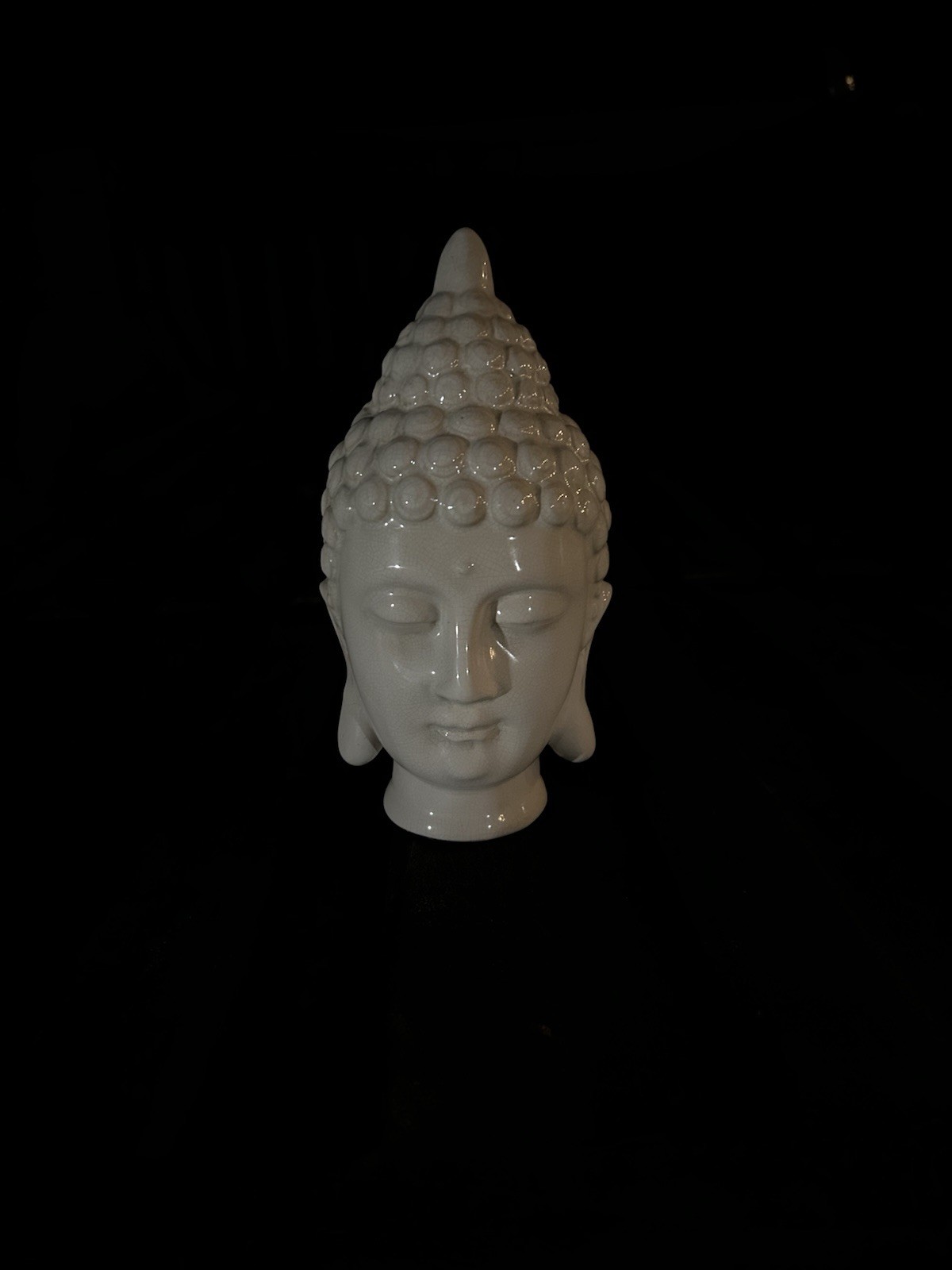 This object is a white ceramic Buddha head statue designed for spiritual spaces.