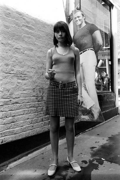 British young woman wearing an optical miniskirt posing front of J- Old Photo