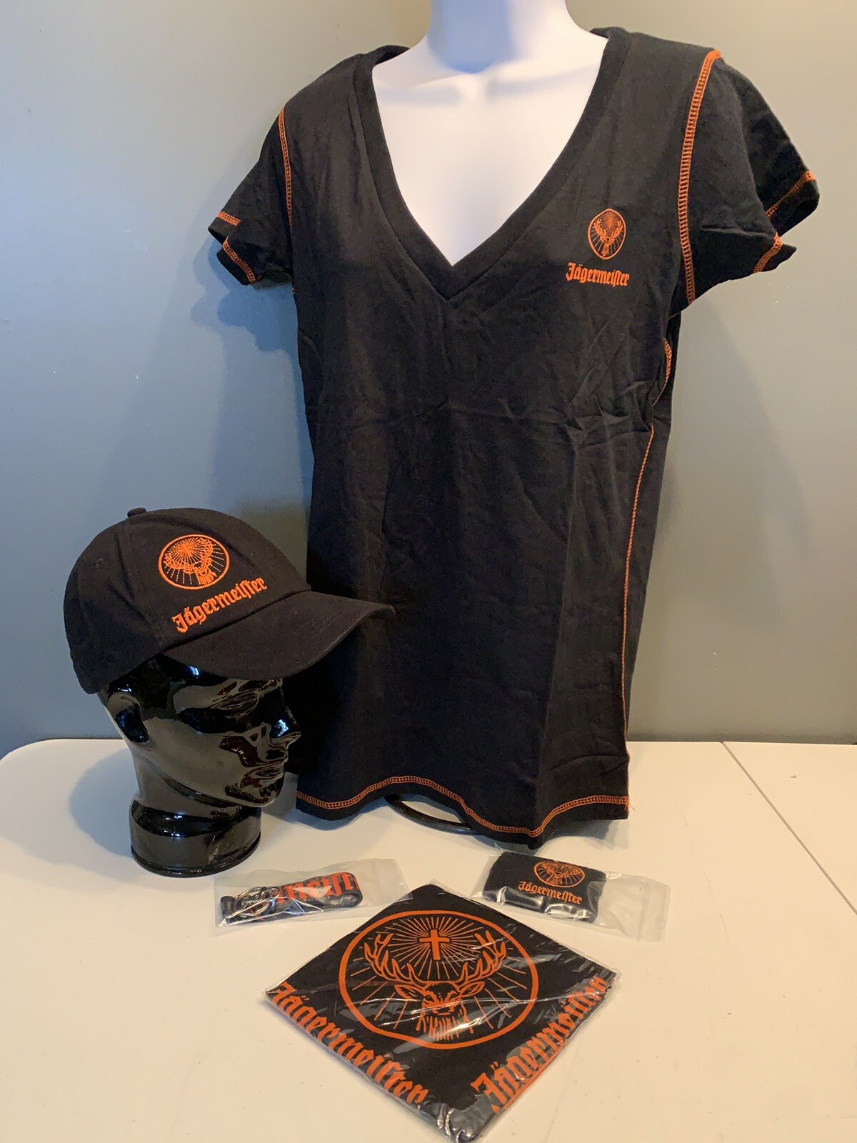 Jagermeister Women’s T-Shirt (M/L), Hat, Bandana, Lanyard, & Wrist Band. Jagermeister Women’s T-Shirt (M/L), Hat, Bandana, Lanyard, & Wrist Band.