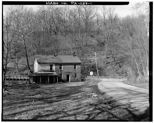 1. VIEW WEST SHOWING EAST (FRONT) ELEVATION AND LOCATION AT JUNCTION OF ROUTES