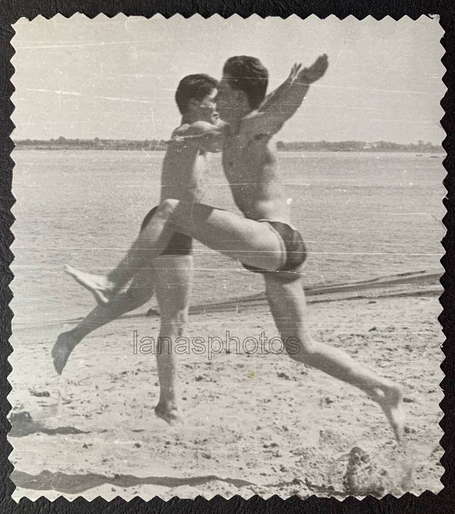 Beach Fun Sports Hover Jump Two handsome men trunks muscle bulge photo Gay Int