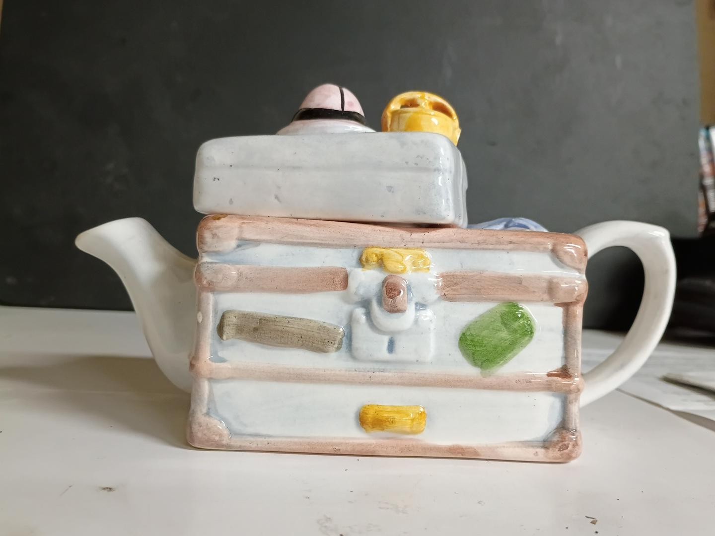 Unique and whimsical ceramic novelty teapot designed to resemble a stack of vint