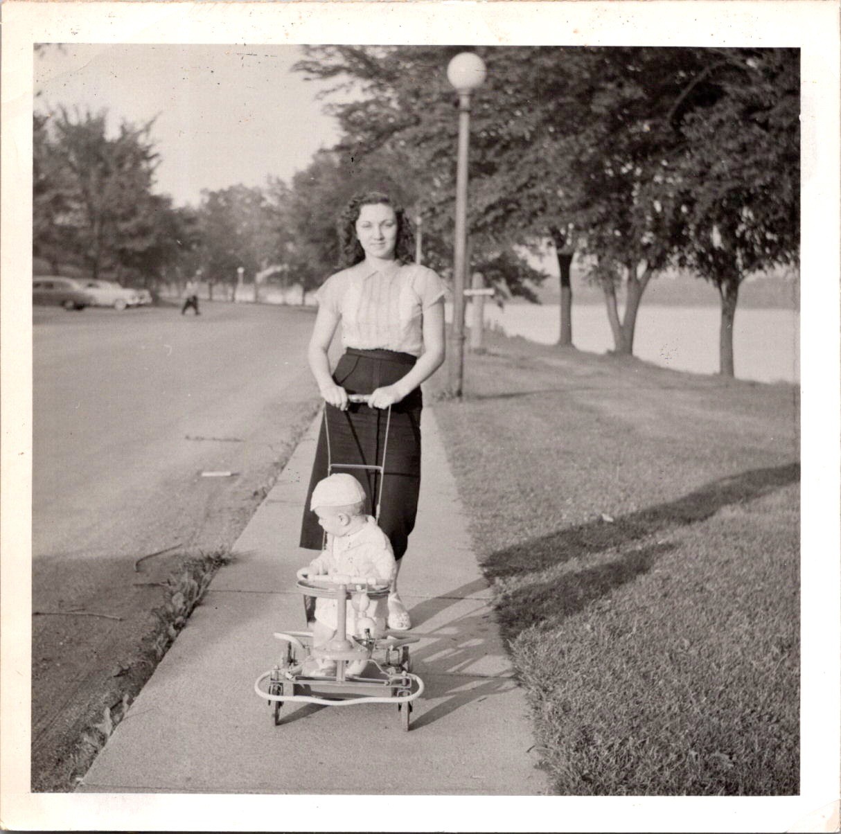 Mother Pushing Baby in Stroller on Park Walkway, 1950s B&W Snapshot Photo Mother Pushing Baby in Stroller on Park Walkway, 1950s B&W Snapshot Photo