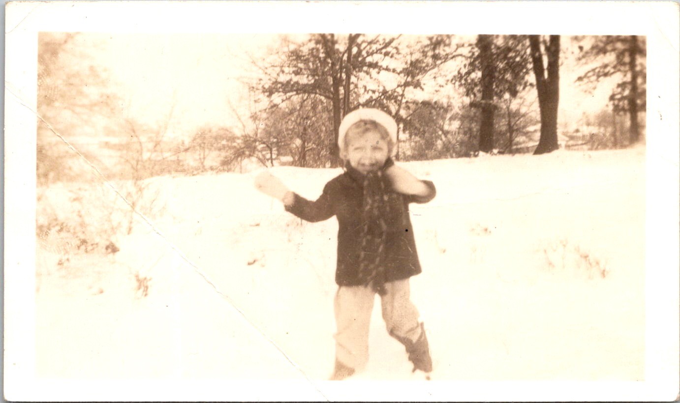 Happy Child Playing in the Winter Snow, 1930s Sepia Snapshot Photo Happy Child Playing in the Winter Snow, 1930s Sepia Snapshot Photo