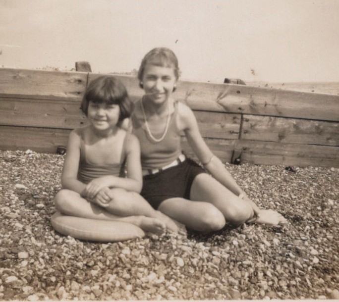 1930s Two Girls Seated On Pebble Beach Seaside Childhood Group Portrait