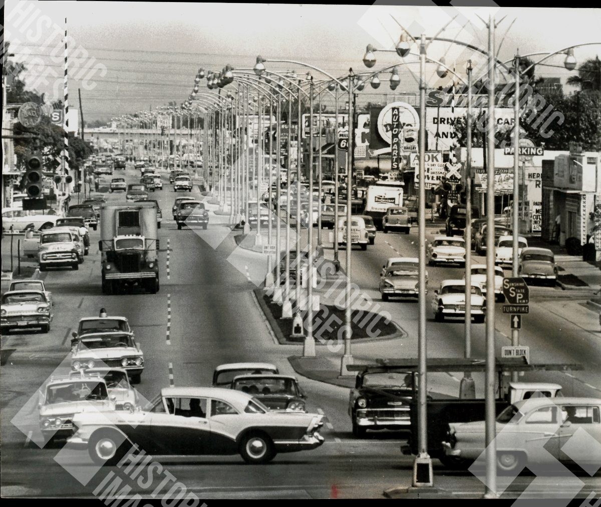 1963 A busy street with many cars and street lights 1963 A busy street with many cars and street lights