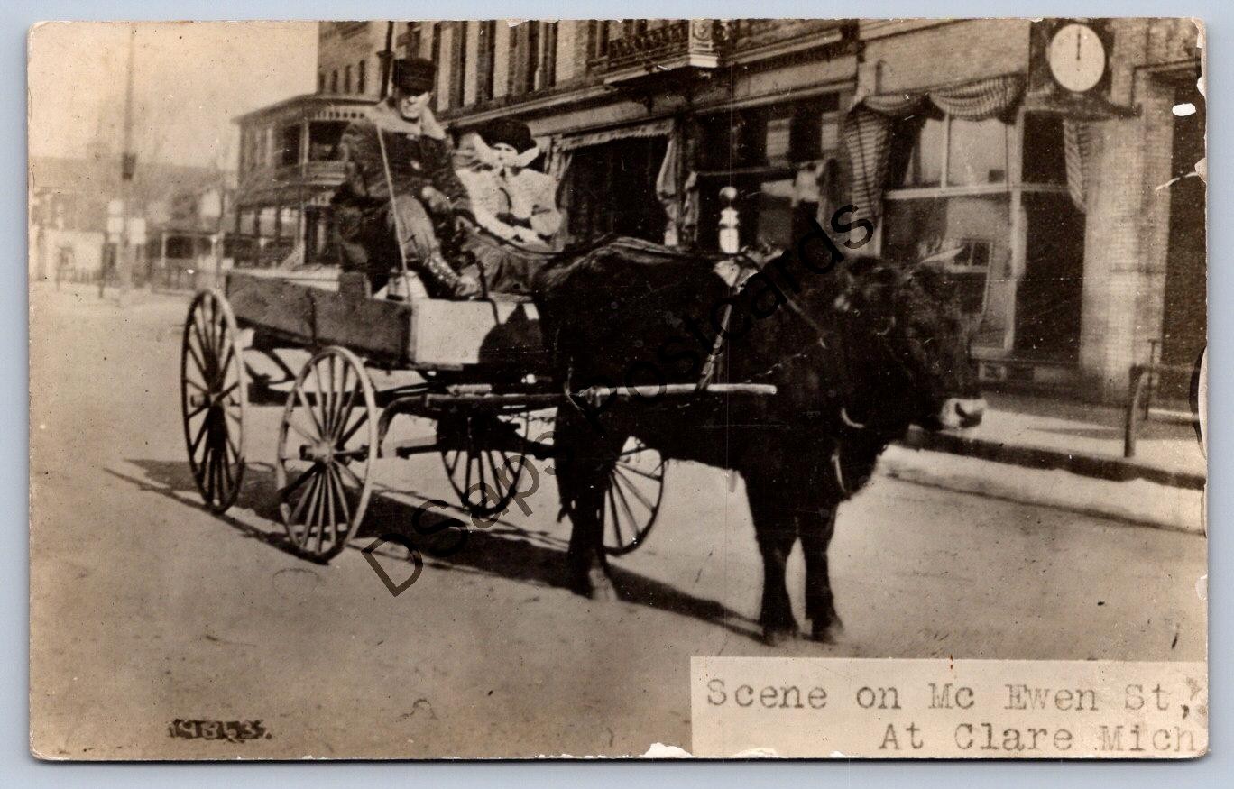 K64/ Clare Michigan RPPC Postcard c1910 Cattle-Drawn Wagon Men Ewen St 261