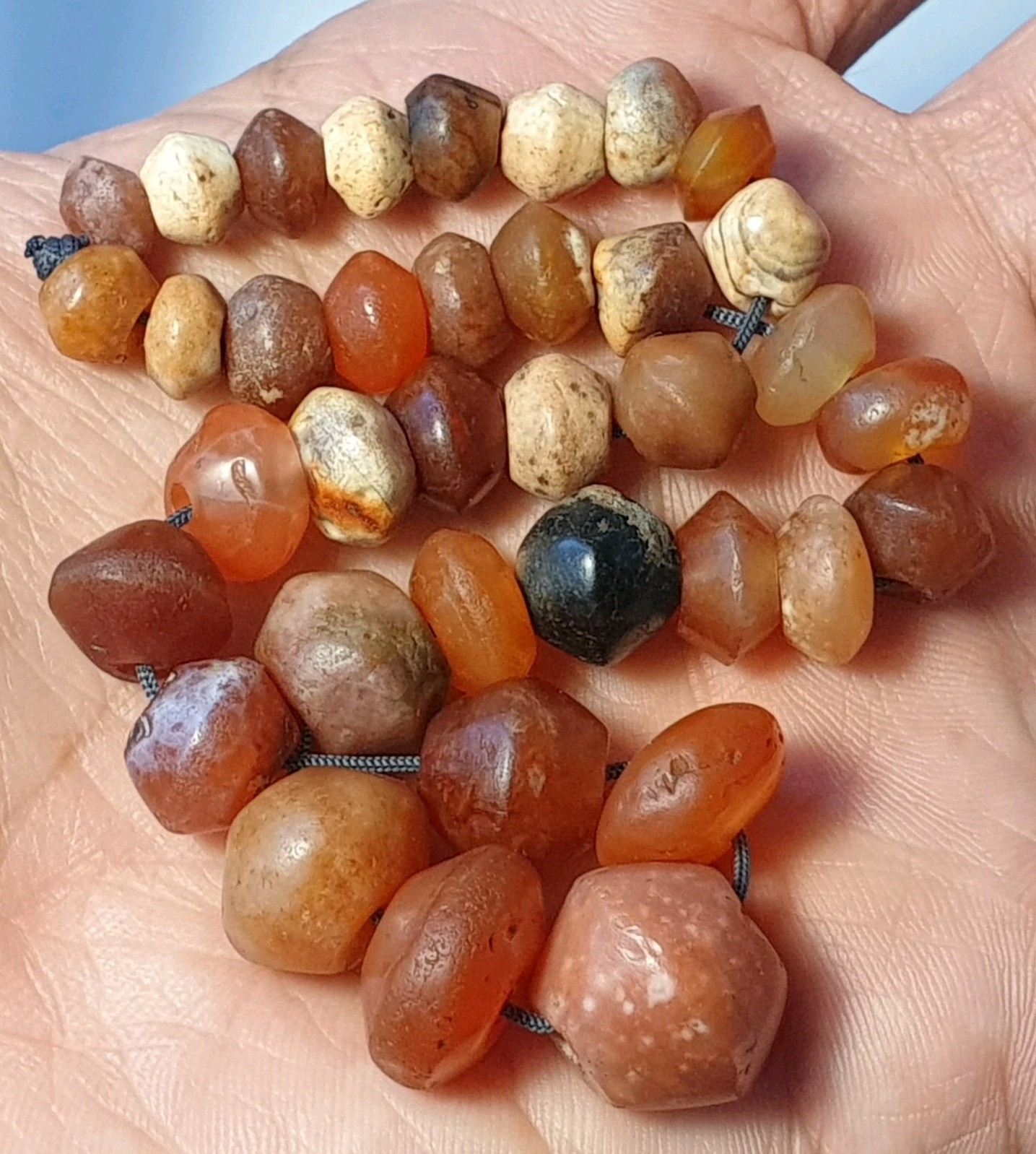 A STRAND OF 36 ANCIENT WESTERN ASIAN CARNELIAN BICONE AGATE BEADS (8mm to 16mm)
