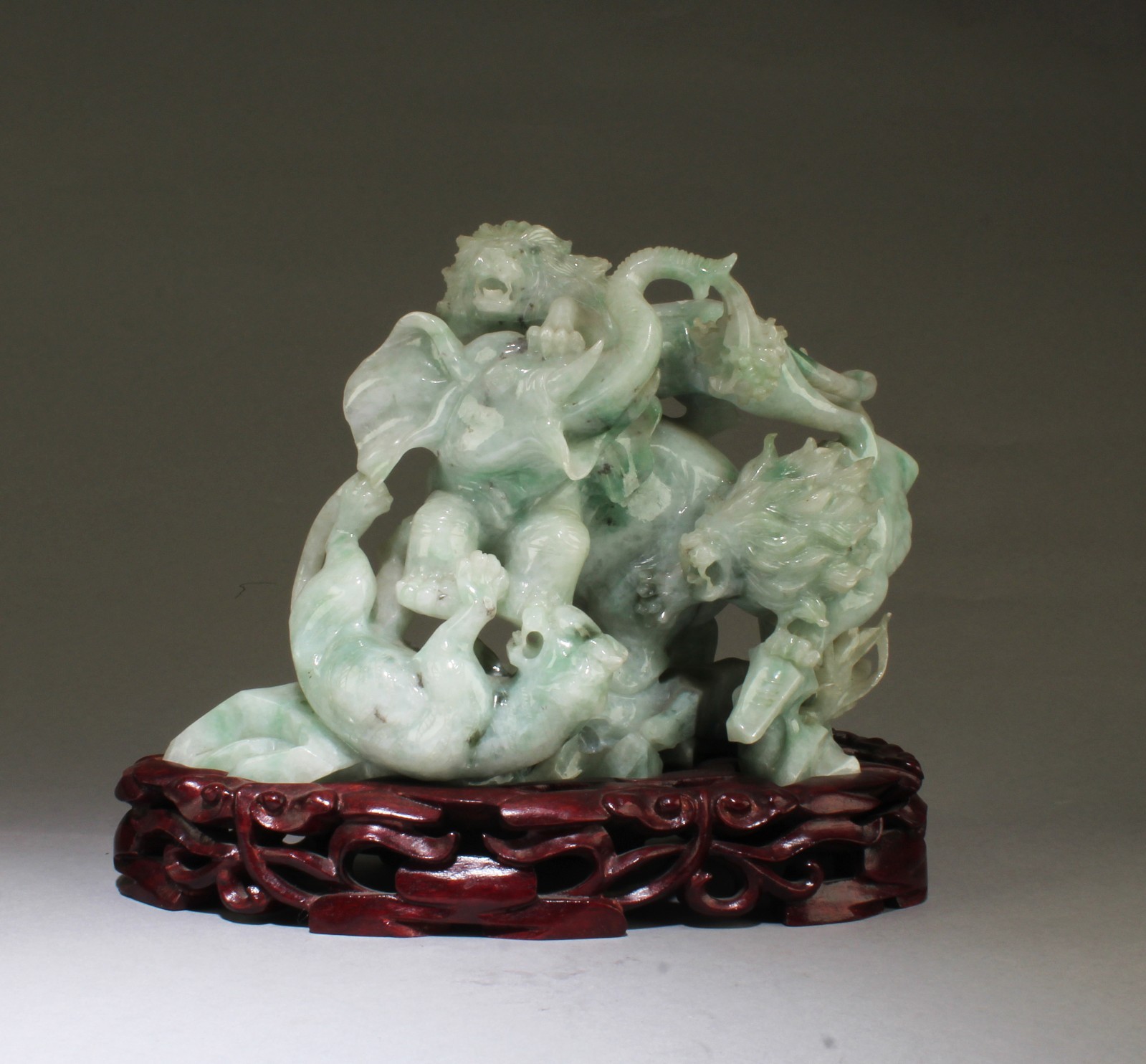 A Chinese Carved Jade Figurine. Comes fitted with a wooden stand A Chinese Carved Jade Figurine. Comes fitted with a wooden stand