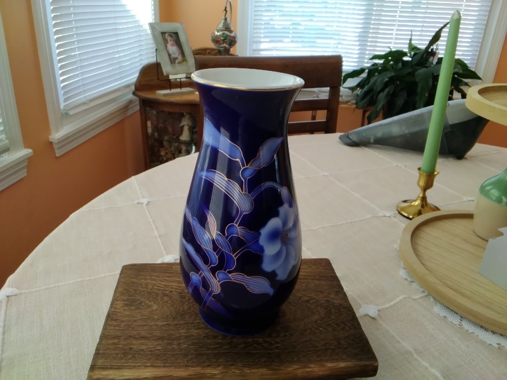 A cobalt blue Fukagawa porcelain vase with a peony motif and gold accents.