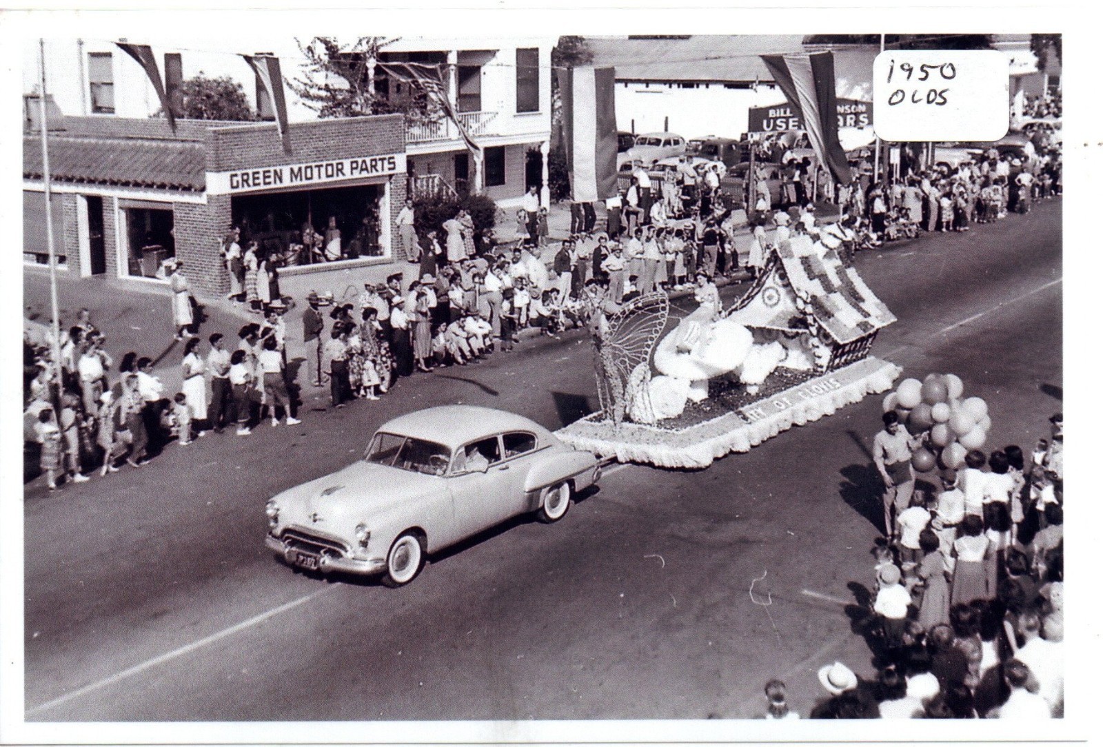 Street Scene Parade with 1950 Oldsmobile Pulling Float Photo