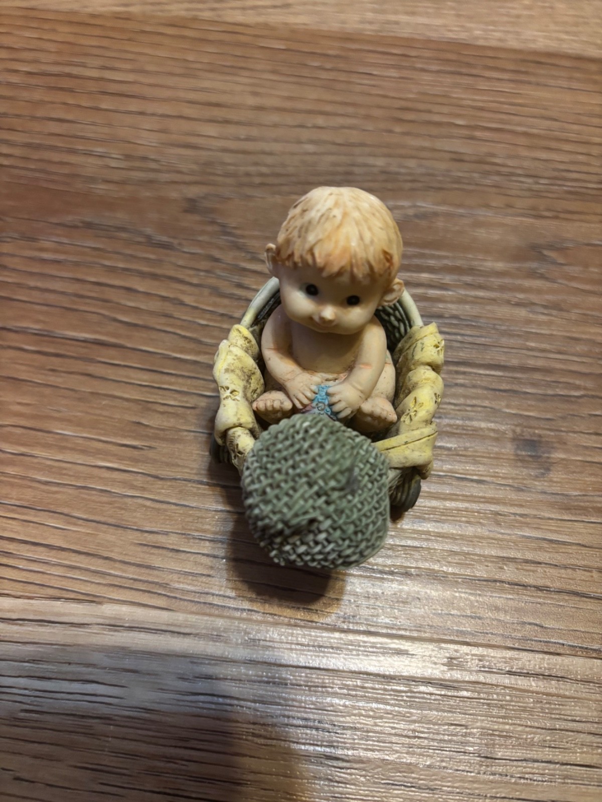 vintage small blonde baby sitting in a wheeled basket 