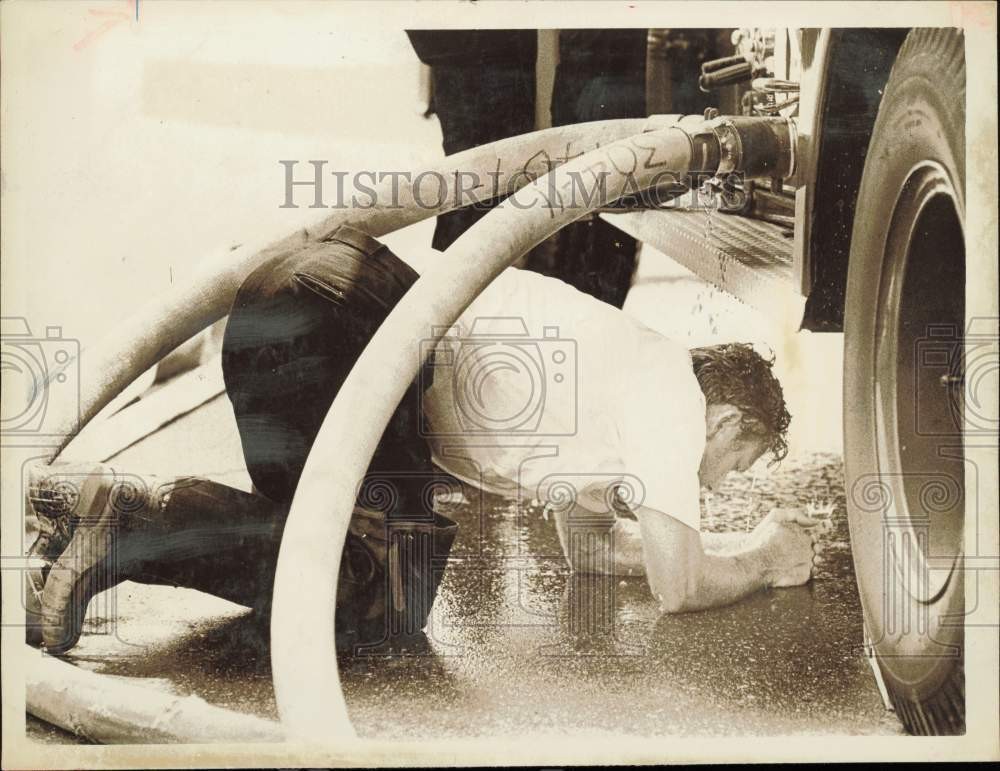 1970 Press Photo M.W. Penninger cools off under dripping firehose in Charlotte
