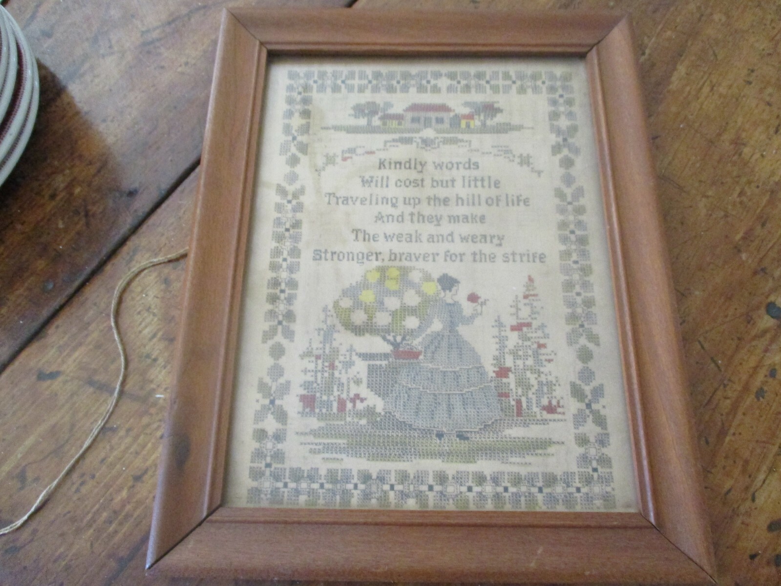 Framed sampler inspired saying under glass. 