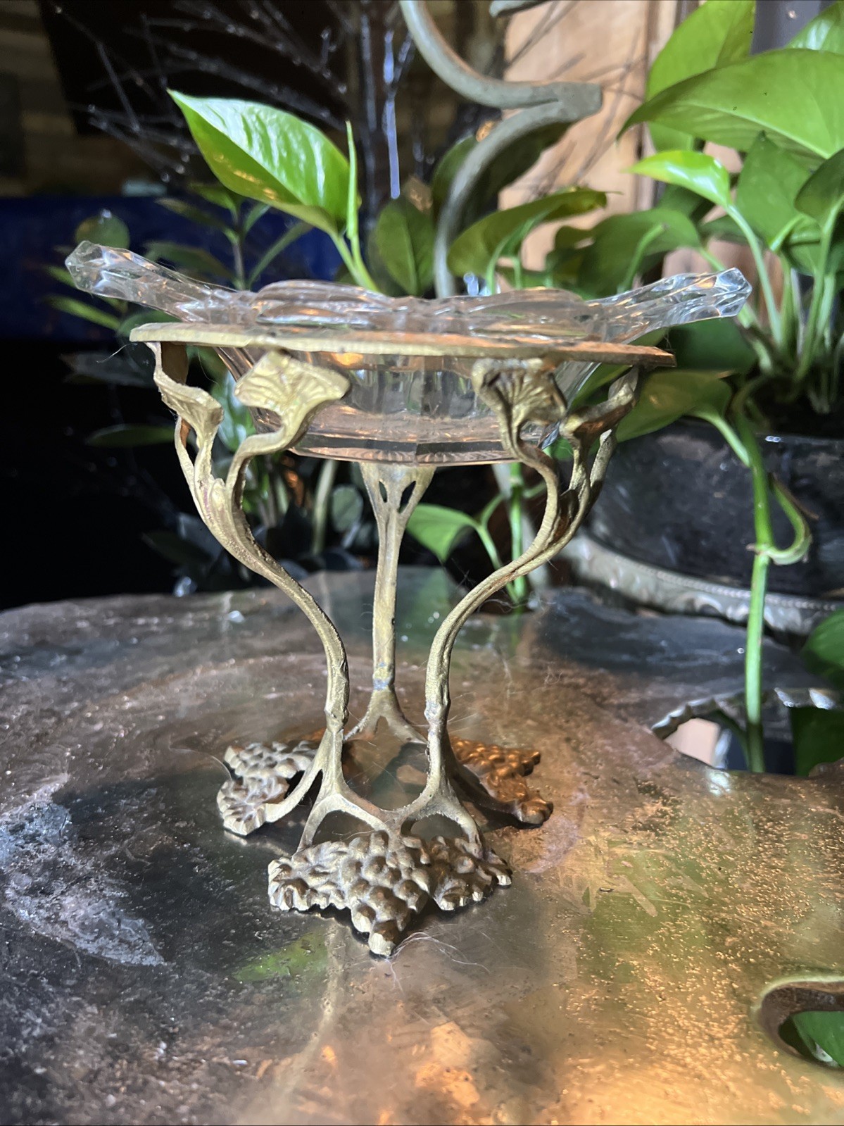 Antique brass pedestal stand featuring a detailed grapevine and leaf motif Antique brass pedestal stand featuring a detailed grapevine and leaf motif