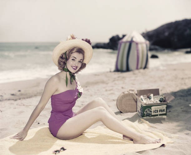 Young woman in swimwear at beach portrait smiling Historic 1960s Old Photo