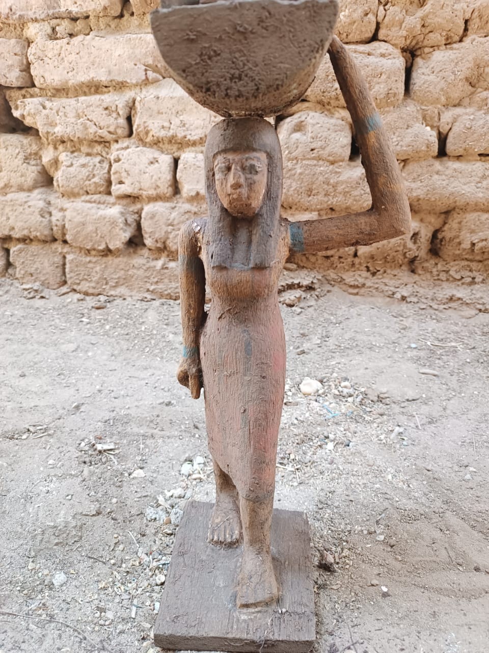 Ancient egyptian antique wooden statue of woman carrying basket in daily life