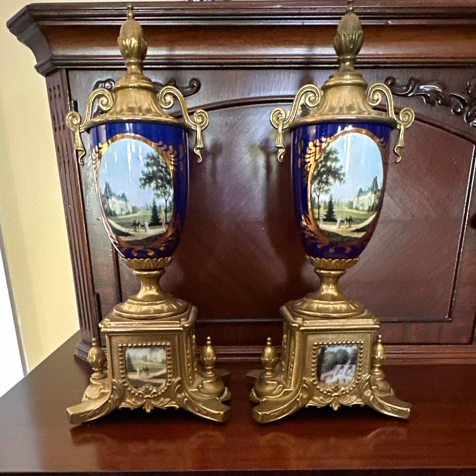Pair Blue & Gold Lidded Urn Vases, Scenic Landscape Panels, Metal Base Pair Blue & Gold Lidded Urn Vases, Scenic Landscape Panels, Metal Base
