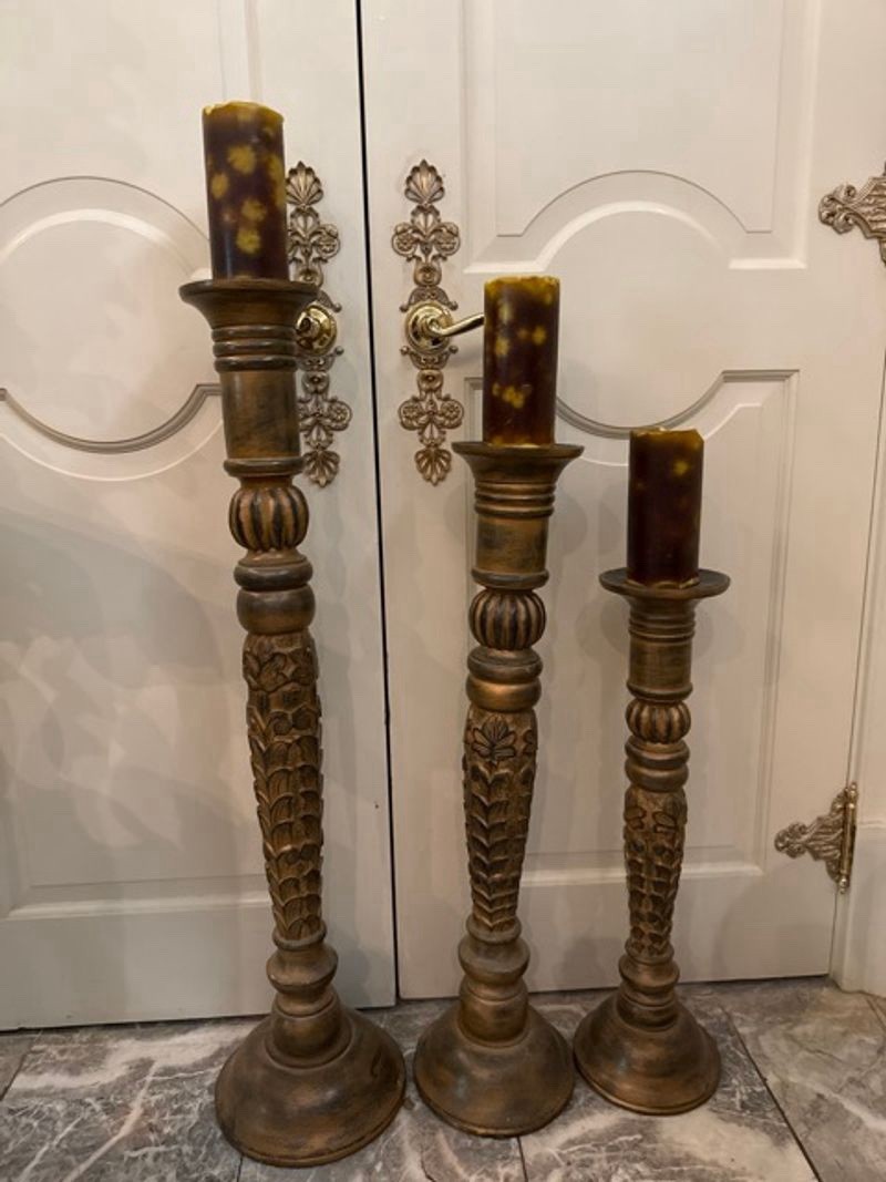 Three wooden carved floor-standing candle holders