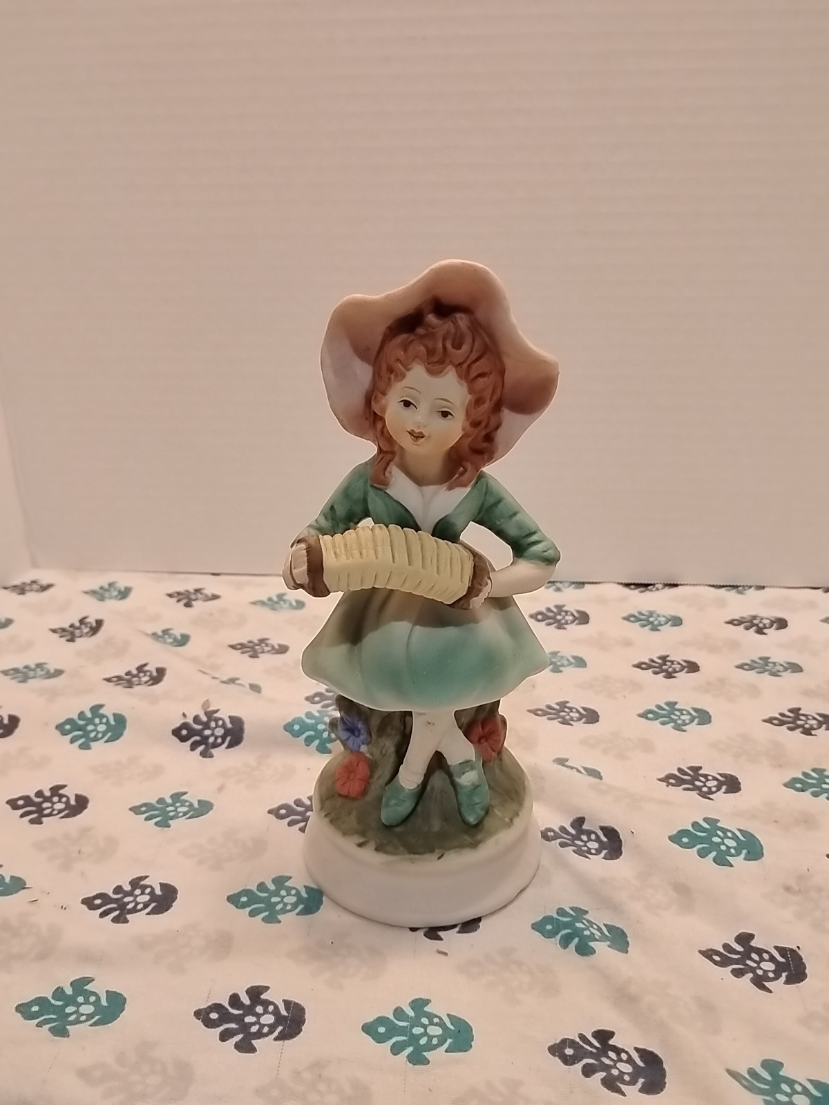 vintage porcelain or bisque figurine of a girl playing an accordion. vintage porcelain or bisque figurine of a girl playing an accordion.