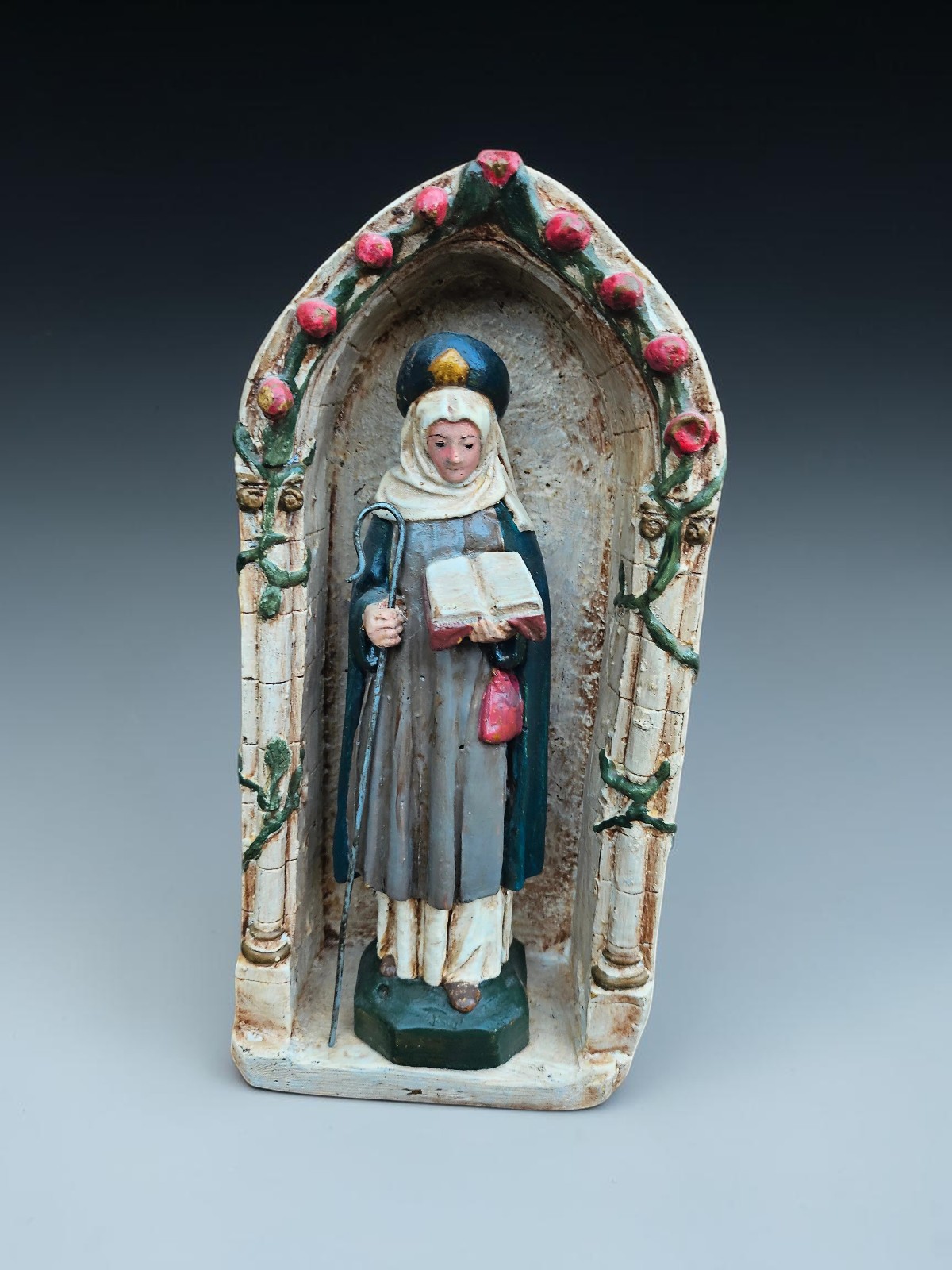 Antique chalk statue Of Saint Bona of Pisa in niche chapel with roses Antique chalk statue Of Saint Bona of Pisa in niche chapel with roses