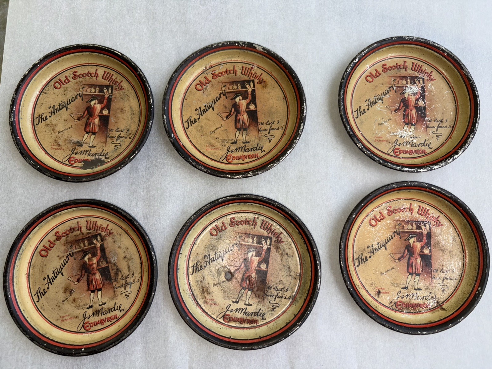 6 VERY RARE PRE PROHIBITION TIP TRAYS “ OLD SCOTCH WHISKY THE ANTIQUARY” app 4” 6 VERY RARE PRE PROHIBITION TIP TRAYS “ OLD SCOTCH WHISKY THE ANTIQUARY” app 4”