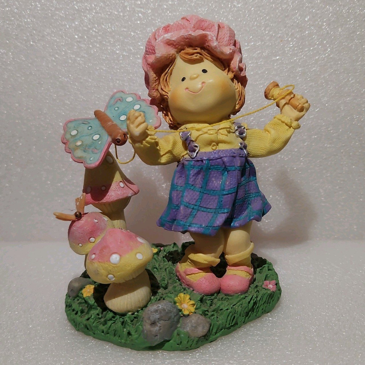 Vintage girl with a butterfly on a rope figurine