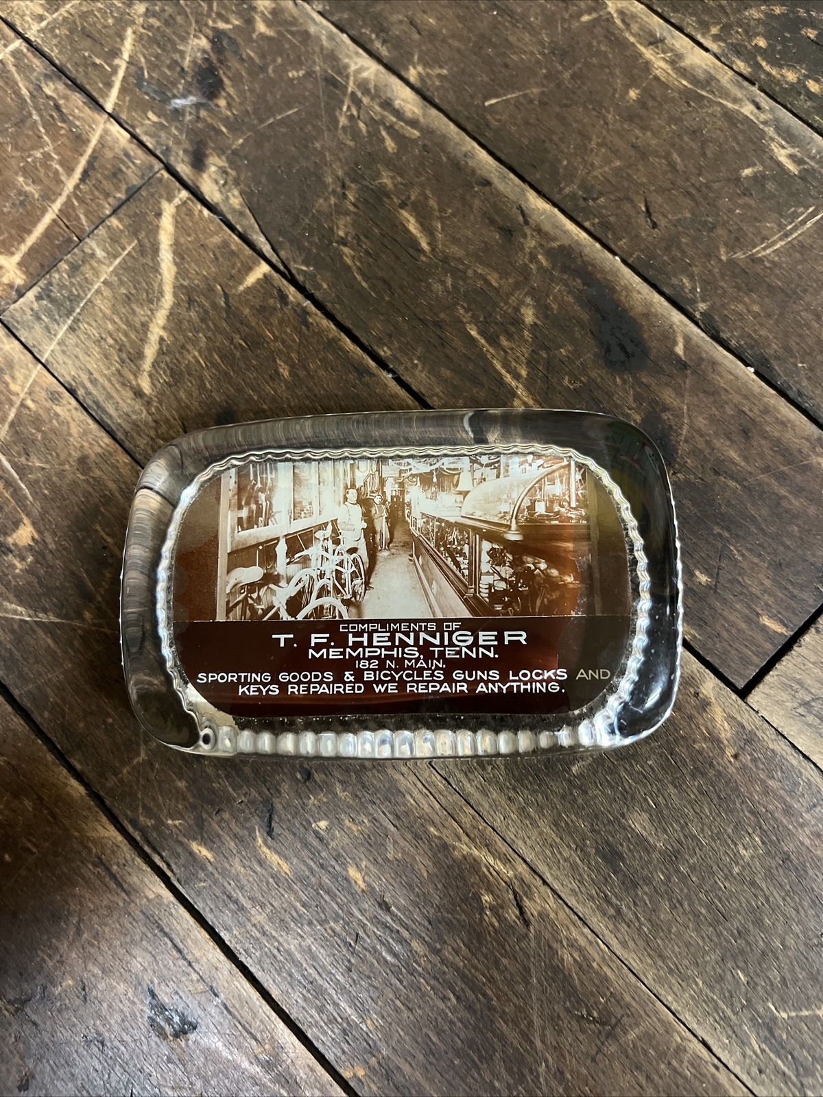 VINTAGE T. F. HENNIGER GLASS PAPERWEIGHT SIGN SPORTING GOODS BICYCLES GUNS STORE