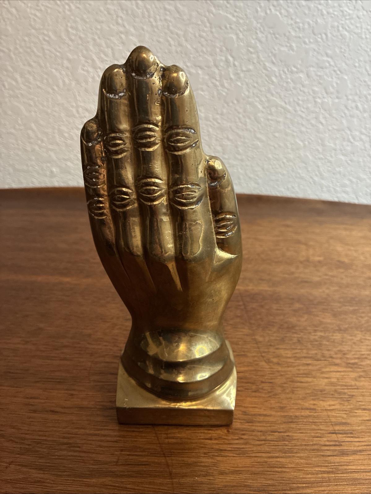 VTG solid brass hand sculpture or bookend, resting on a tiered square pedestal