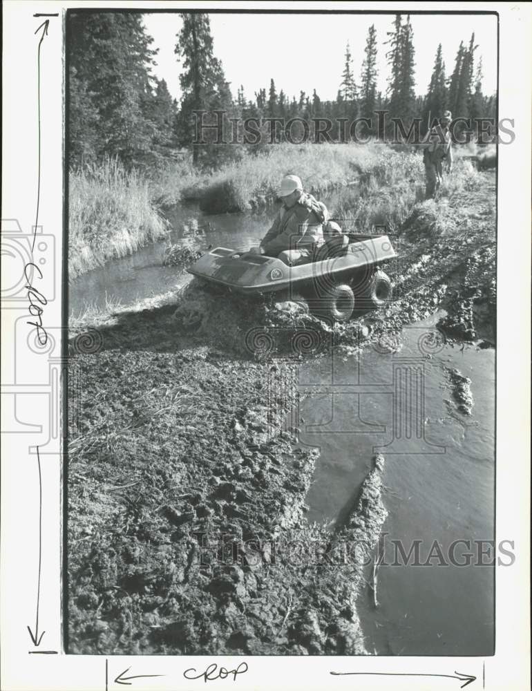 Press Photo Bow hunter Marshall Webb crosses a mud puddle in Hatcher Pass, AK Press Photo Bow hunter Marshall Webb crosses a mud puddle in Hatcher Pass, AK