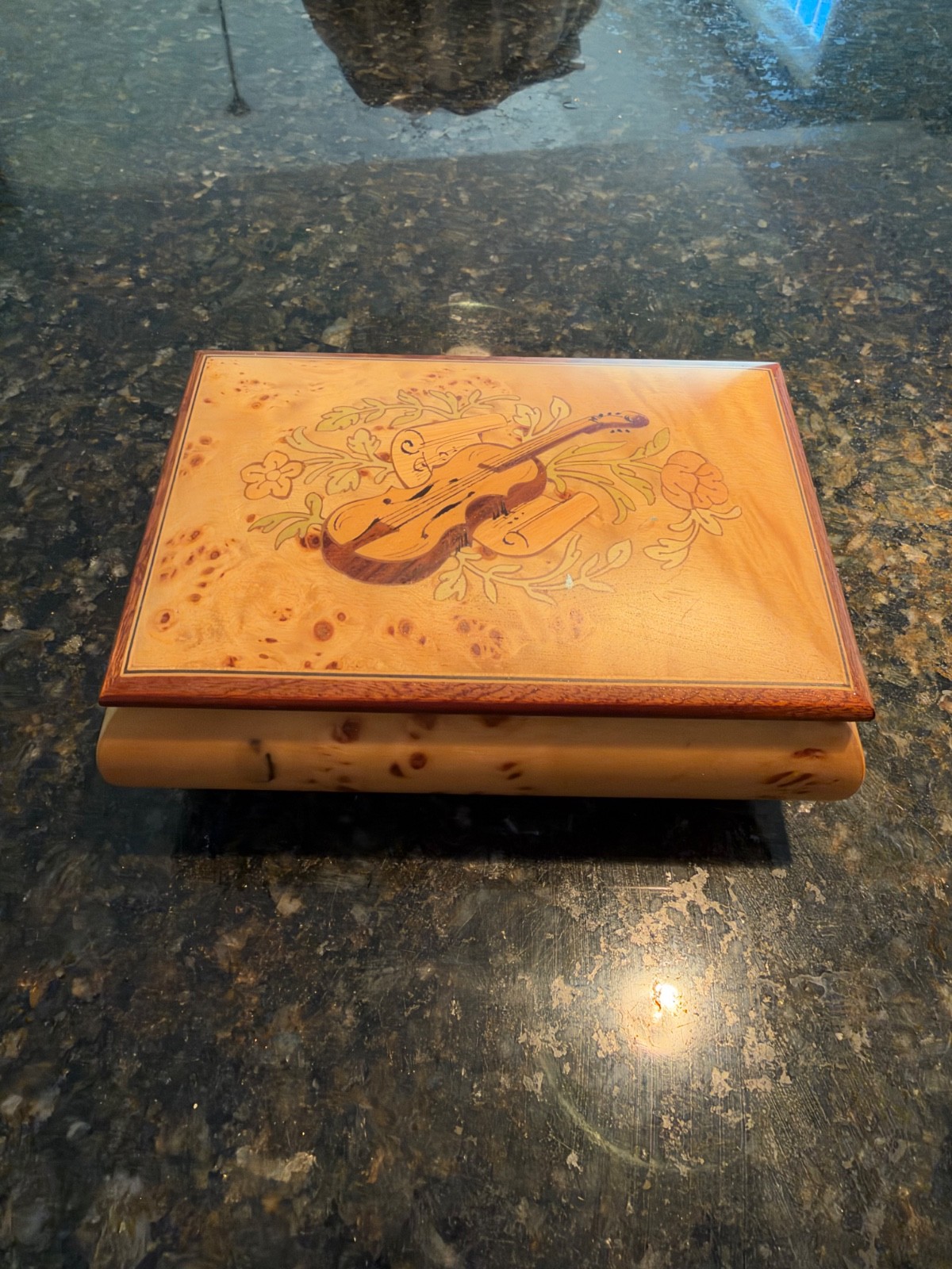 A vintage wooden music or jewelry box featuring a hand-inlaid viol