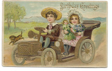 ANTIQUE BIRTHDAY Postcard BOY IN AUTO, GIRL HOLDING DOLL, PUPPY RUNNING ALONG picture