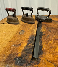 3 antique cast iron irons. And one cast iron trivet picture