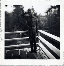 1963 Photograph of Young Boy in Scouting Uniform Saluting on Wooden Deck picture