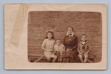 Family portrait three children mother seated in front of brick wall Rppc 1915 picture