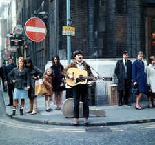 A picture of a general sixties street scene a busker playing a g- Old Photo picture