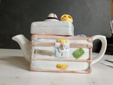Unique and whimsical ceramic novelty teapot designed to resemble a stack of vint picture